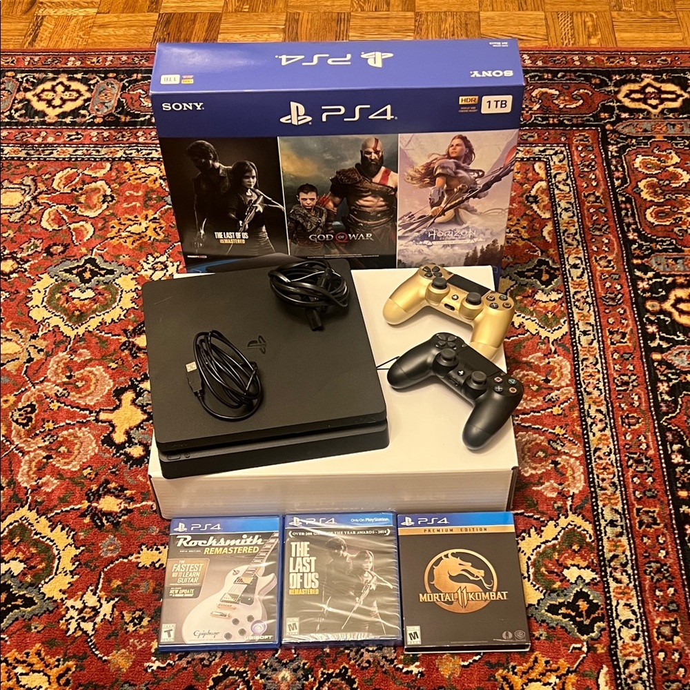Sony PS4 Console 1TB with Black and Gold Controllers, cords, and some games.